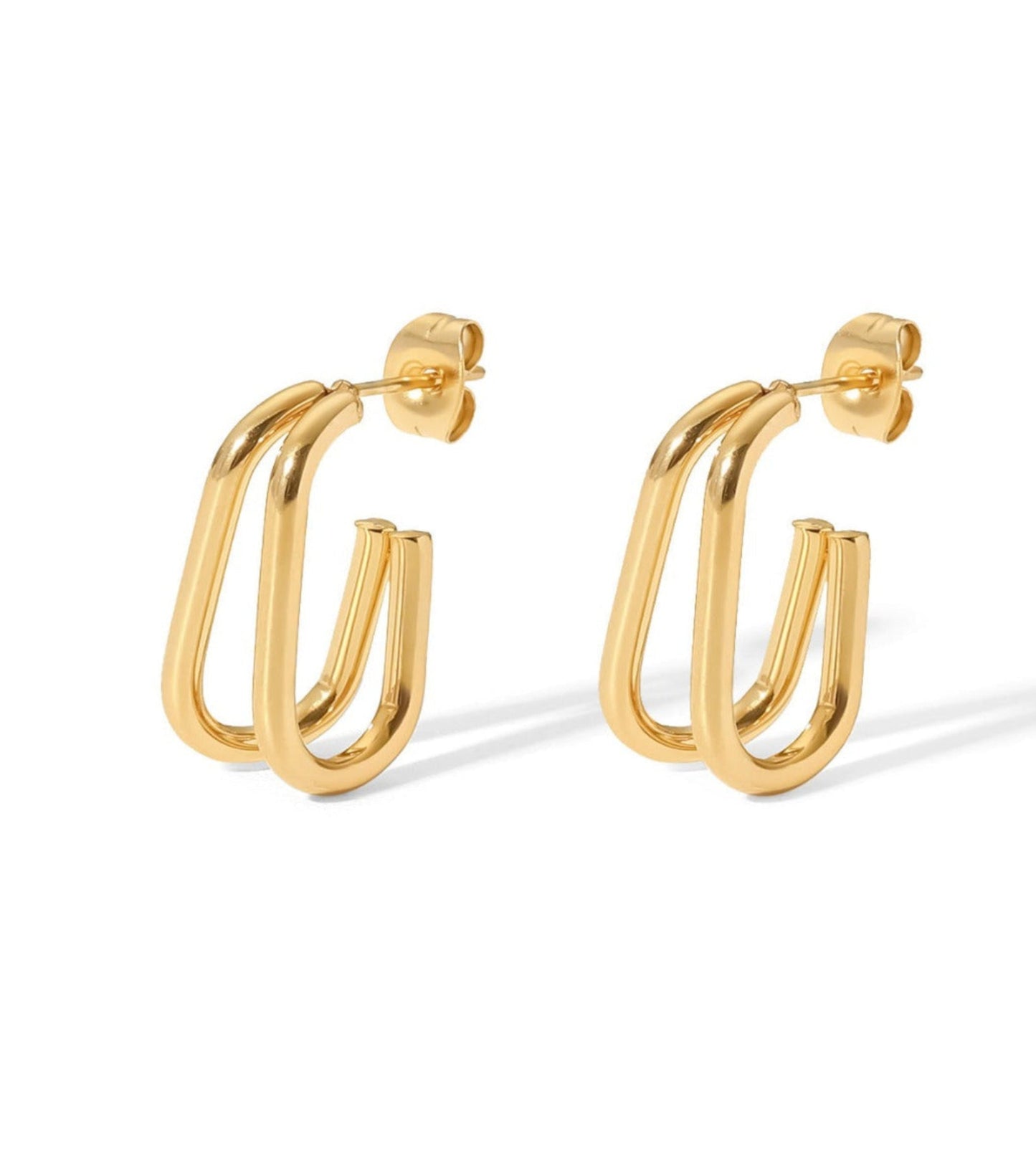 A pair of gold hoop CC earrings with a thick, double-bar curved design, displayed on a clean white background.